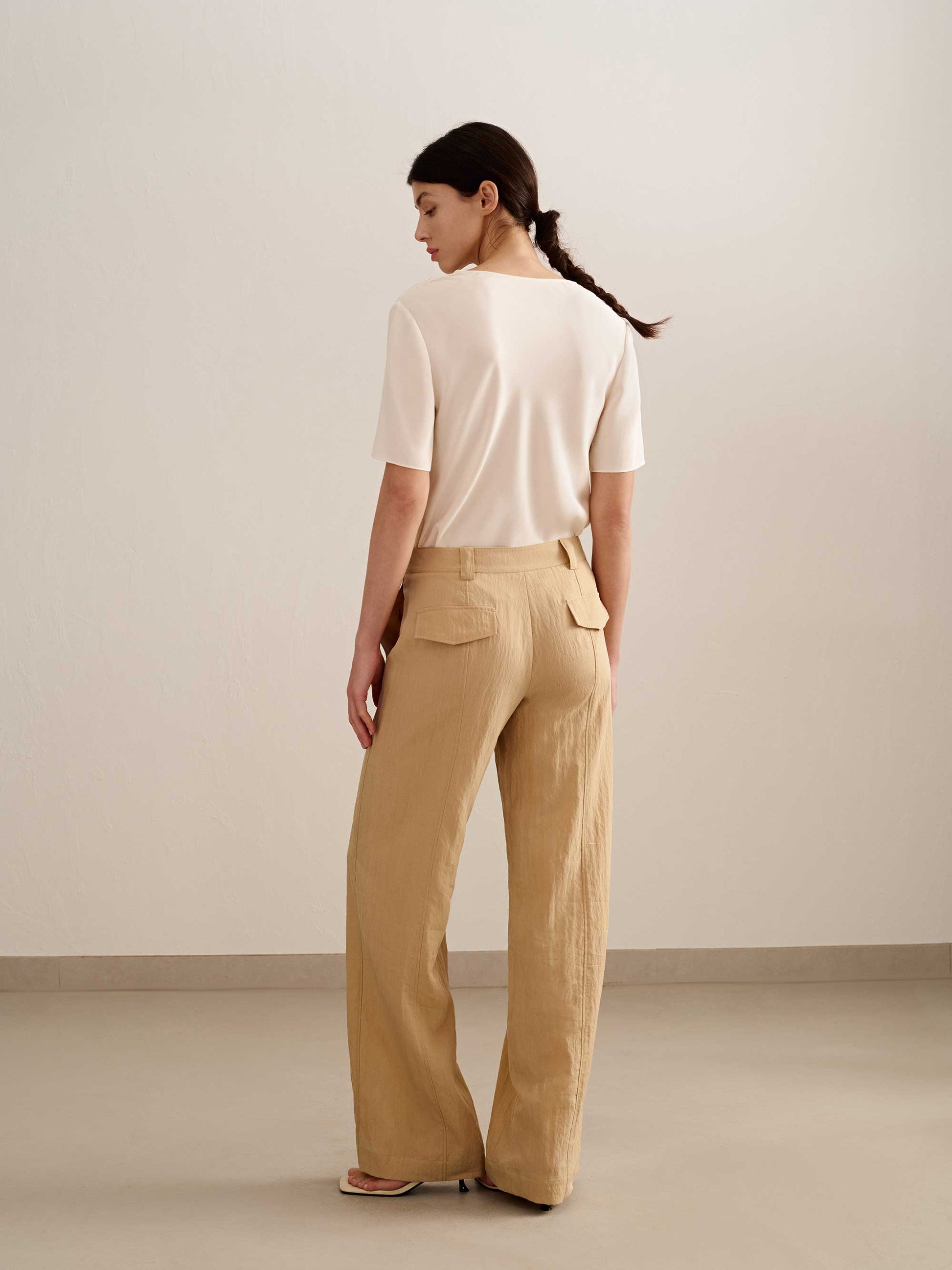 back of a woman wearing a yellow wide leg trousers with white tee