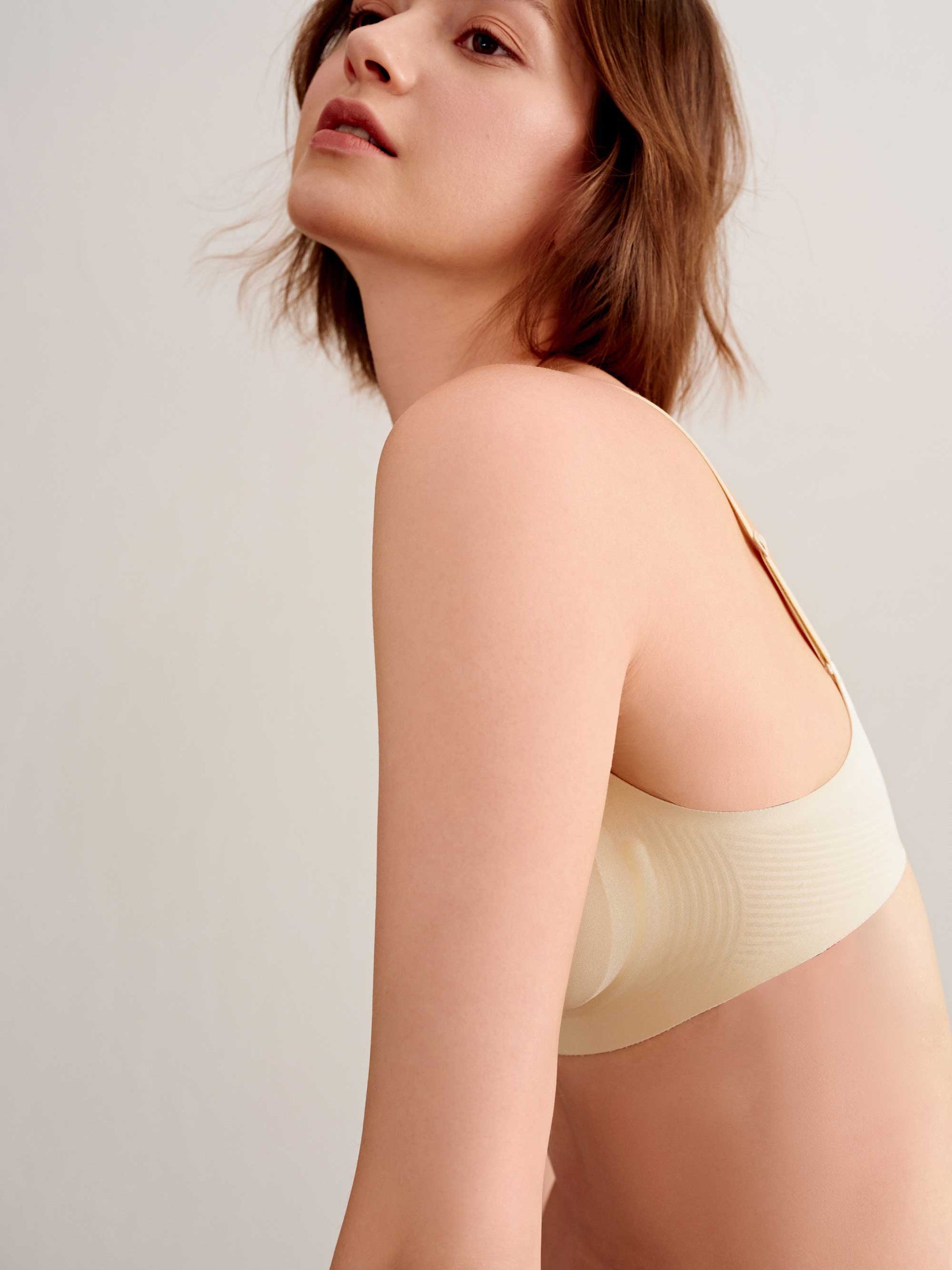 side of woman in cream bra 