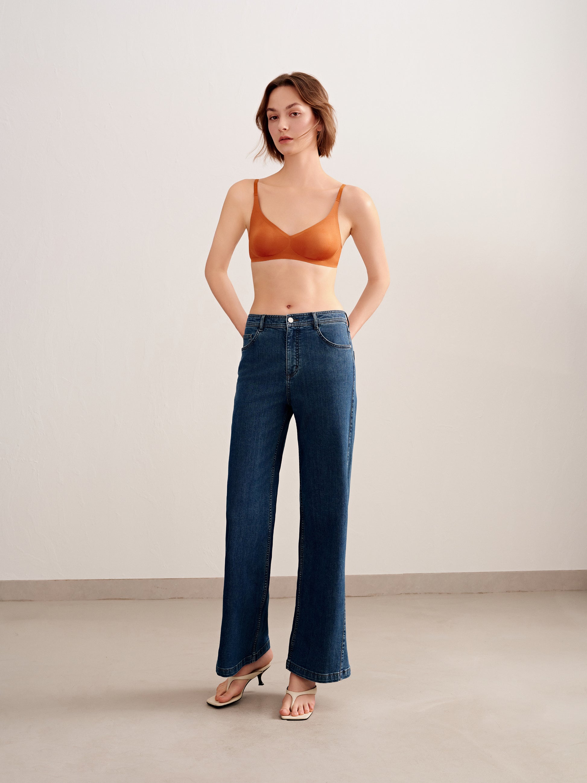 woman in orange bra and jeans