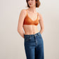 woman in orange bra and jeans