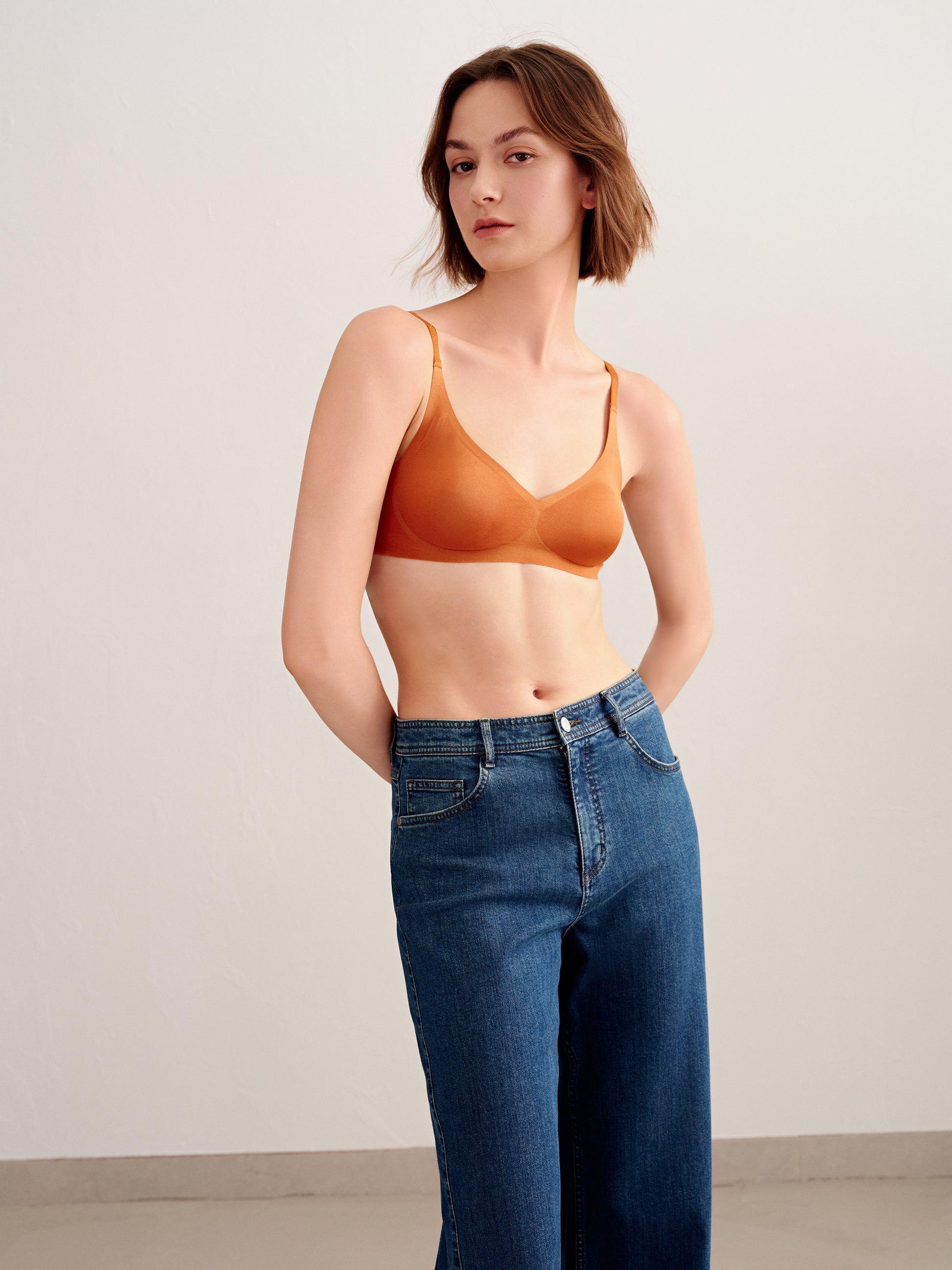 woman in orange bra and jeans
