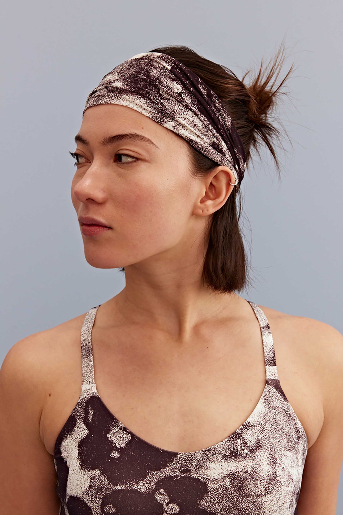 a woman wearing a metallic hairband and metallic sports bra