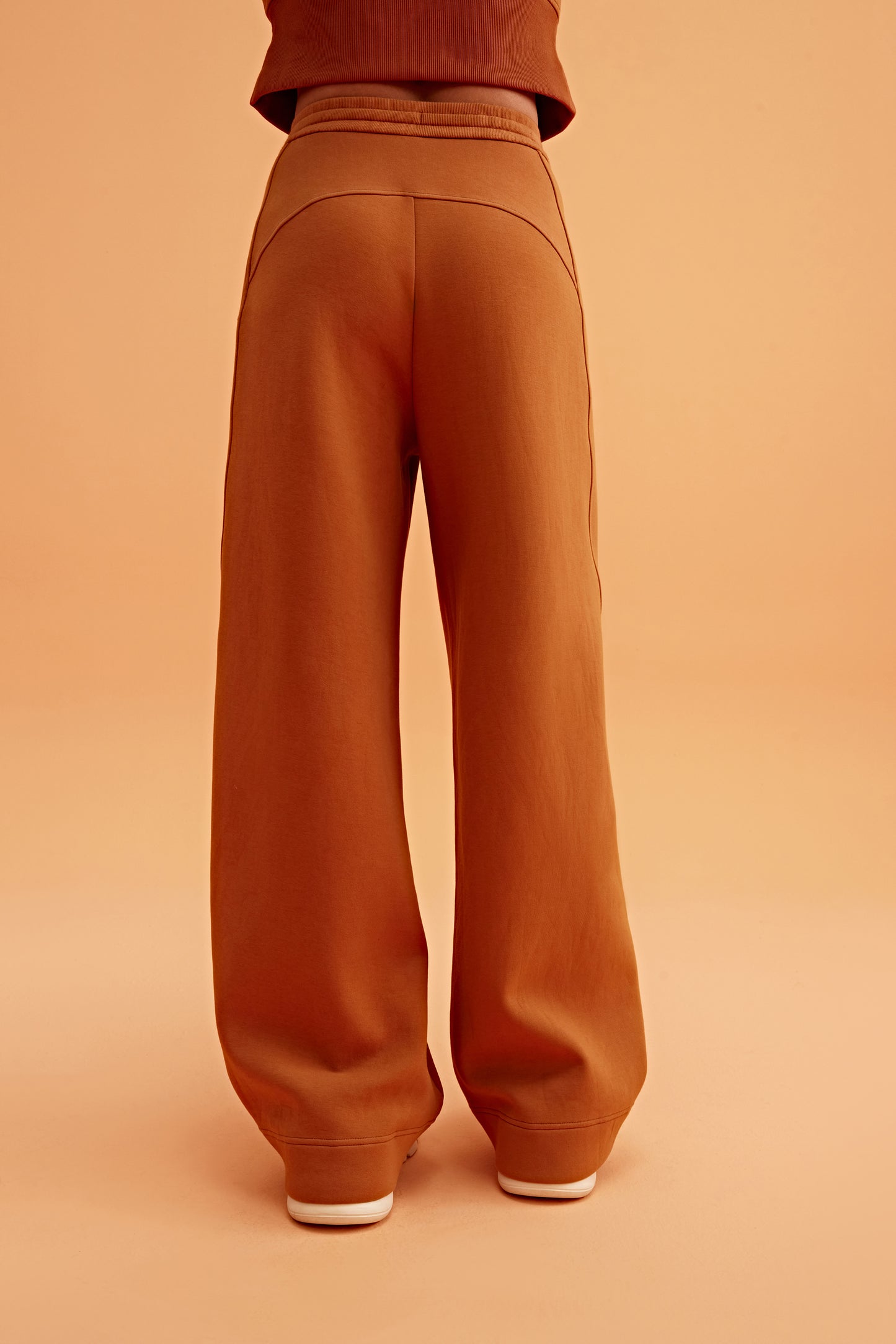 back of woman in caramel wide leg pants
