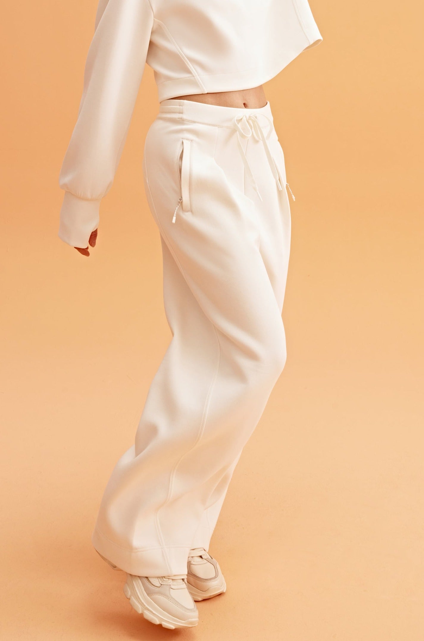 woman in white sweatshirt and wide leg pants