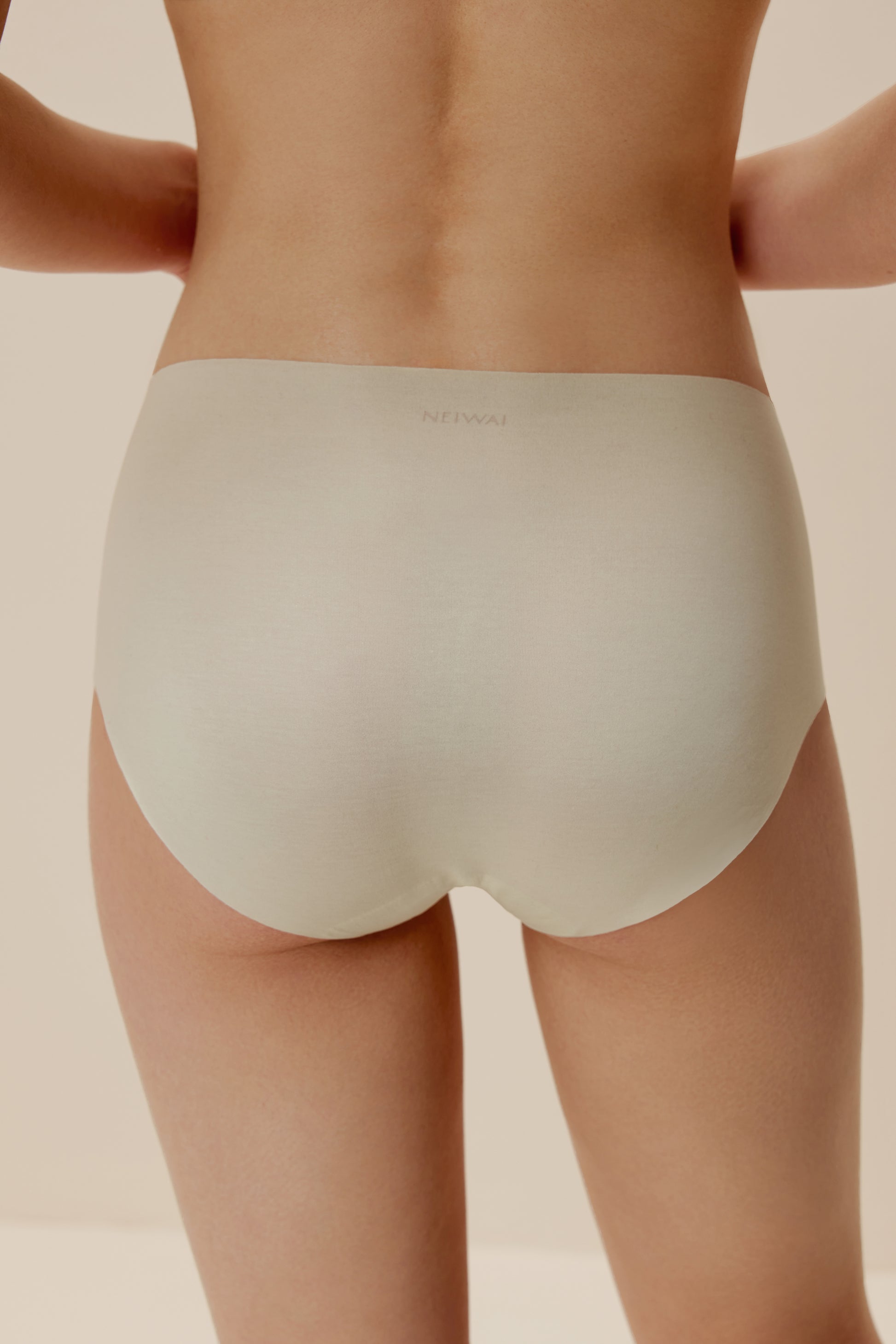 back of woman in off white brief