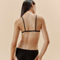 back of a woman wearing a black brief and black bra