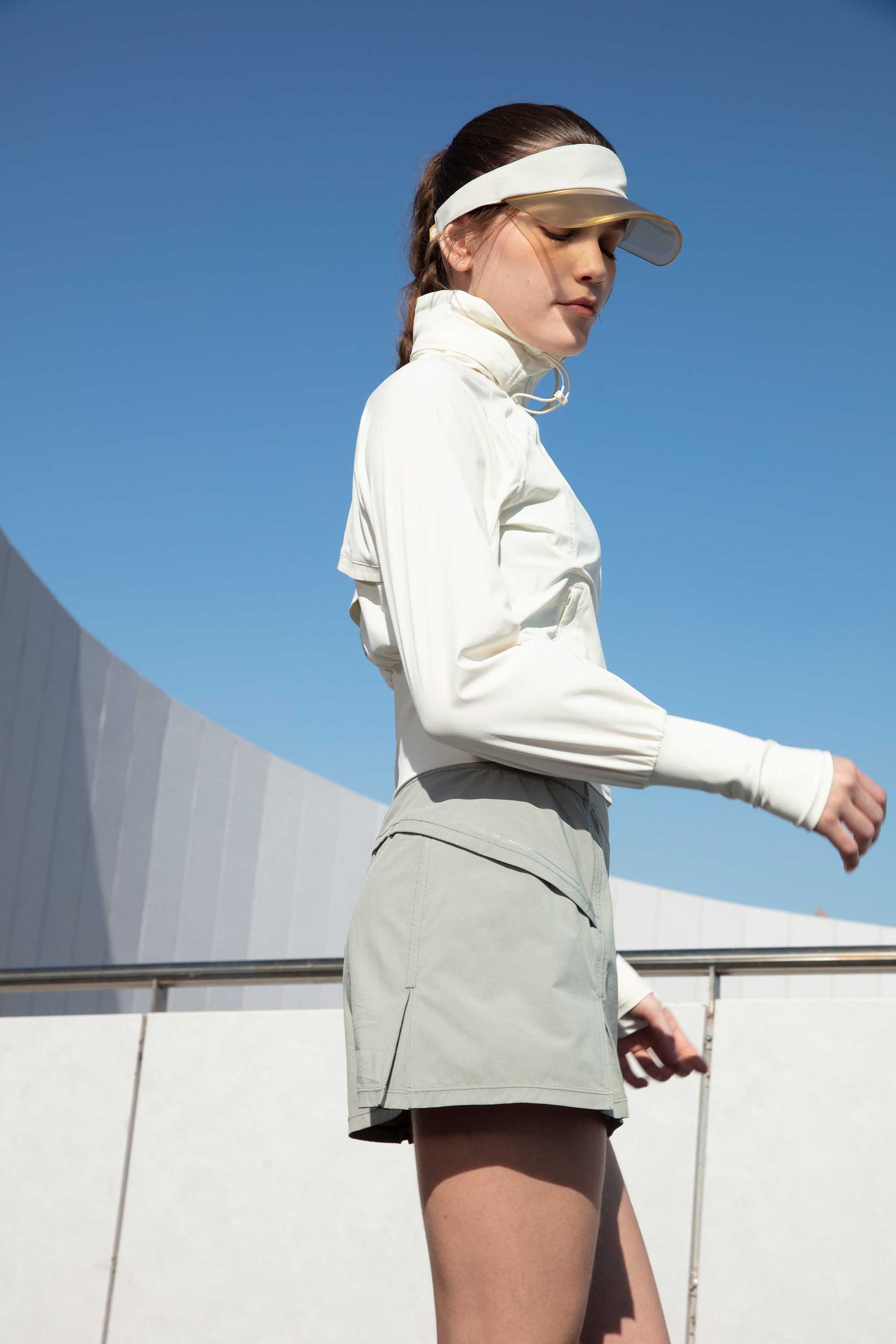 woman in white jacket and grey tennis skort