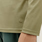 detail of the green long sleeved top with logo