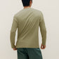 back of man wearing a green long sleeve and dark green pants
