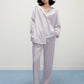 a woman wearing a purple pajama sets and white slippers