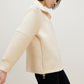 woman with off white jacket from side