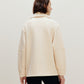 woman with off white jacket from the back