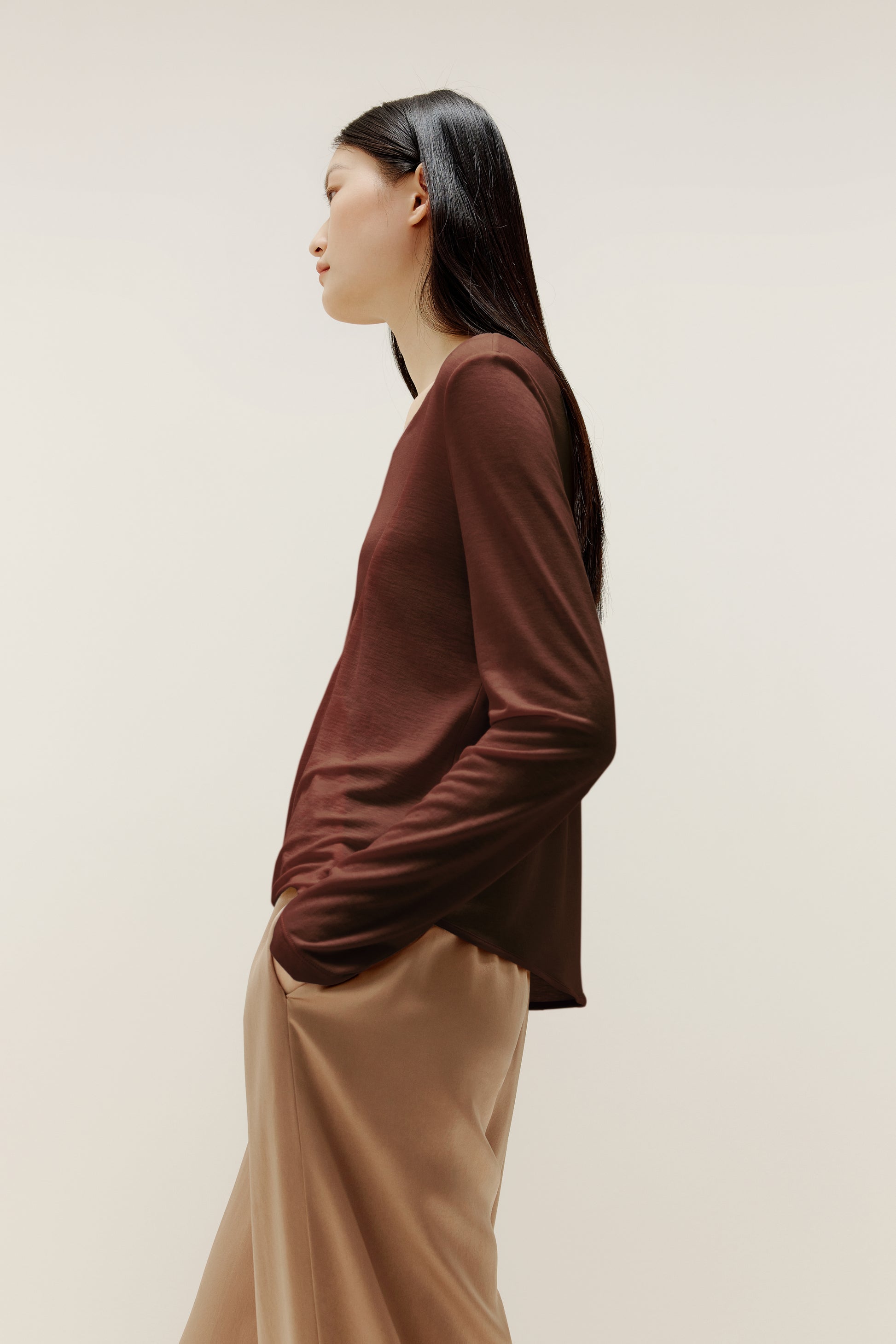 side view of the brown sweater and beige pants.