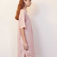 side of woman with pink pajama dress with white sketches