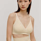woman in cream color cross over bra and high waist bottom