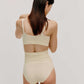 back of woman in cream color bra and high waist brief