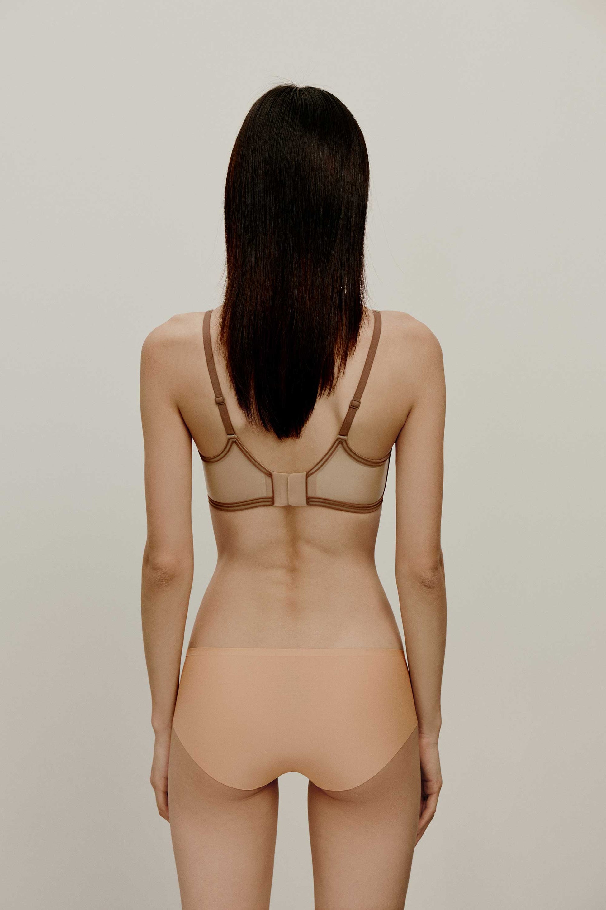 back of woman in tan bra
