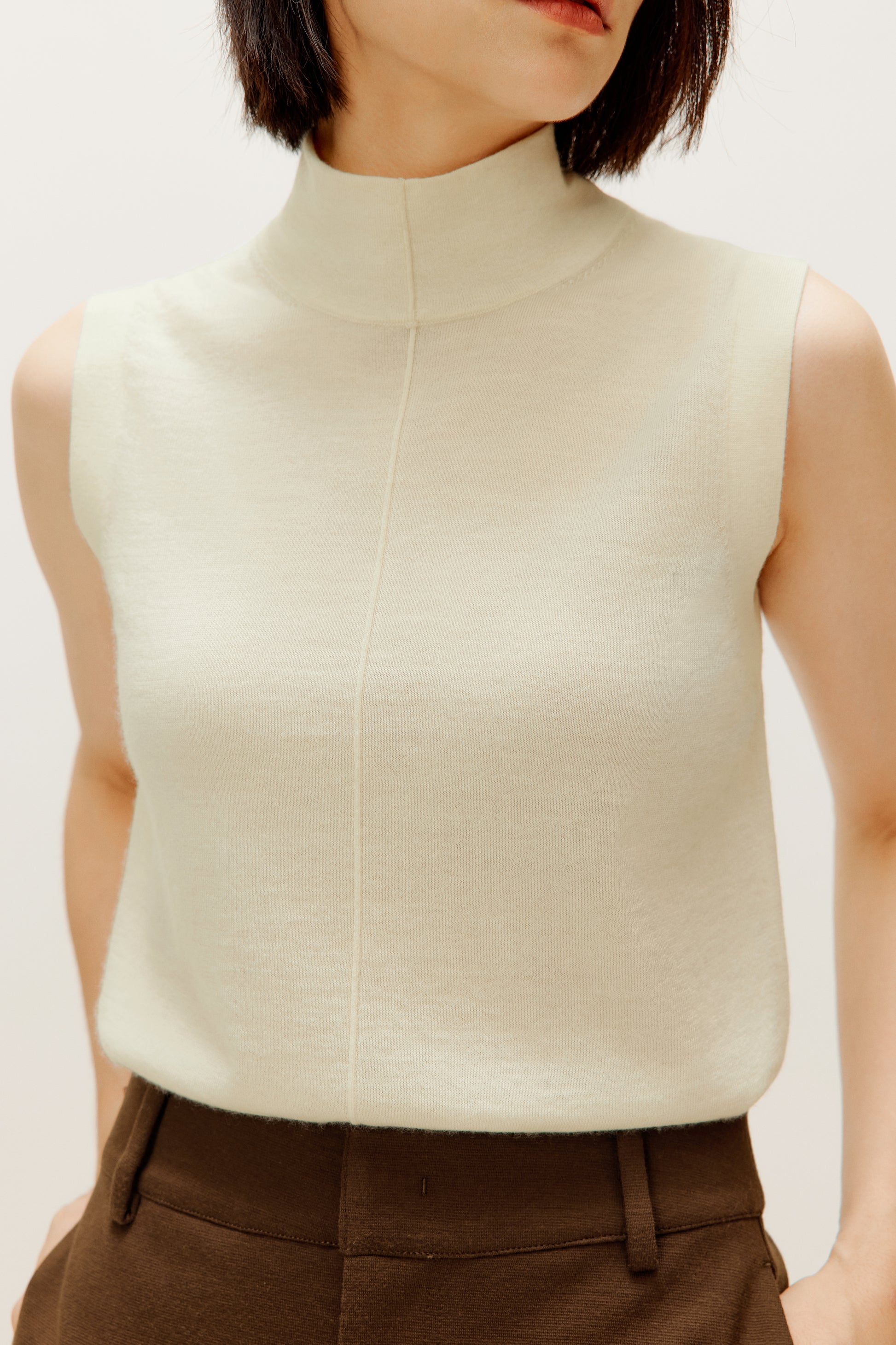 close up of the white silky wool mock neck sleeveless sweater 