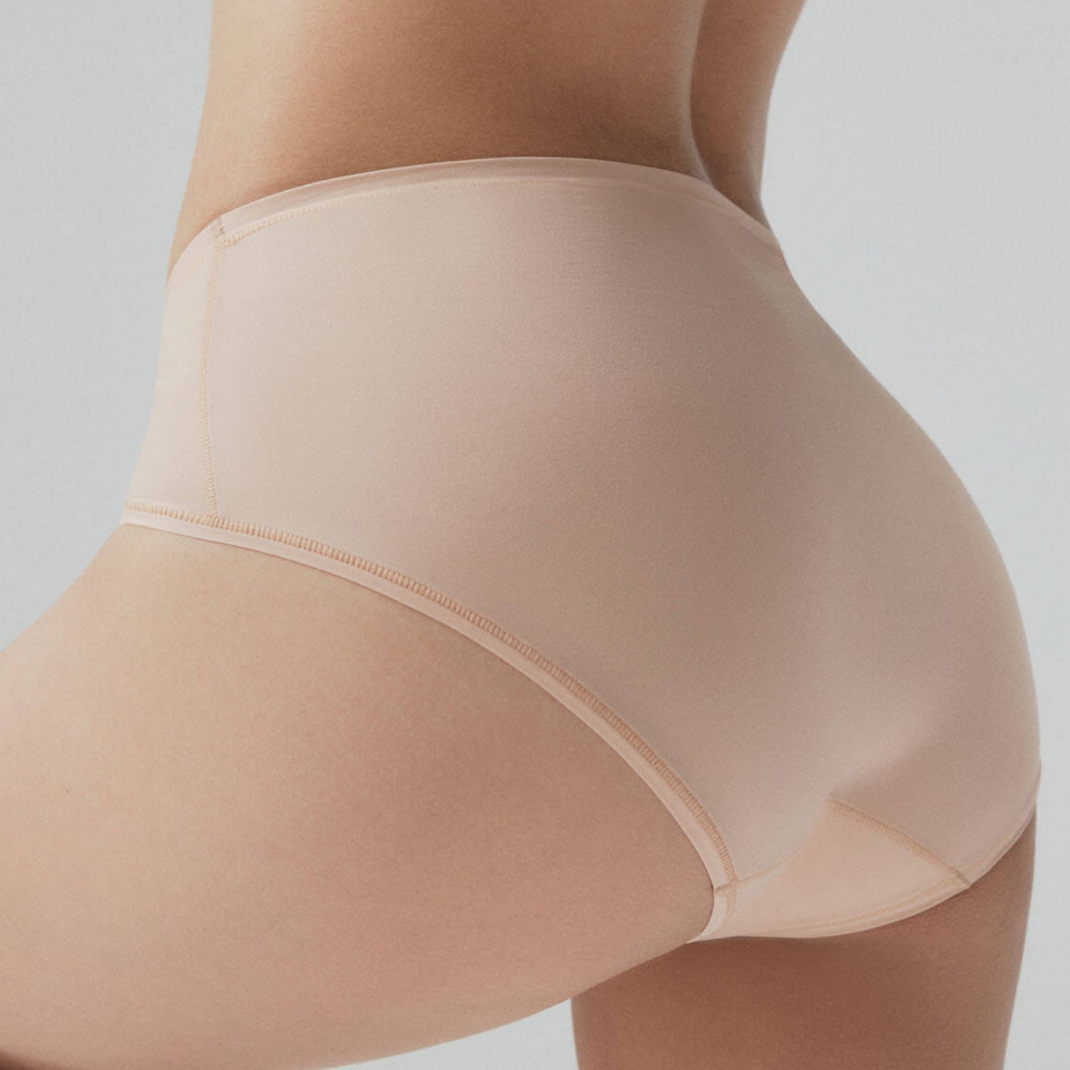 Beige shapewear being worn on a plain background