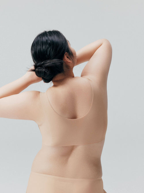 Back view of model wearing nude bra and brief set. Treacly Almond color.