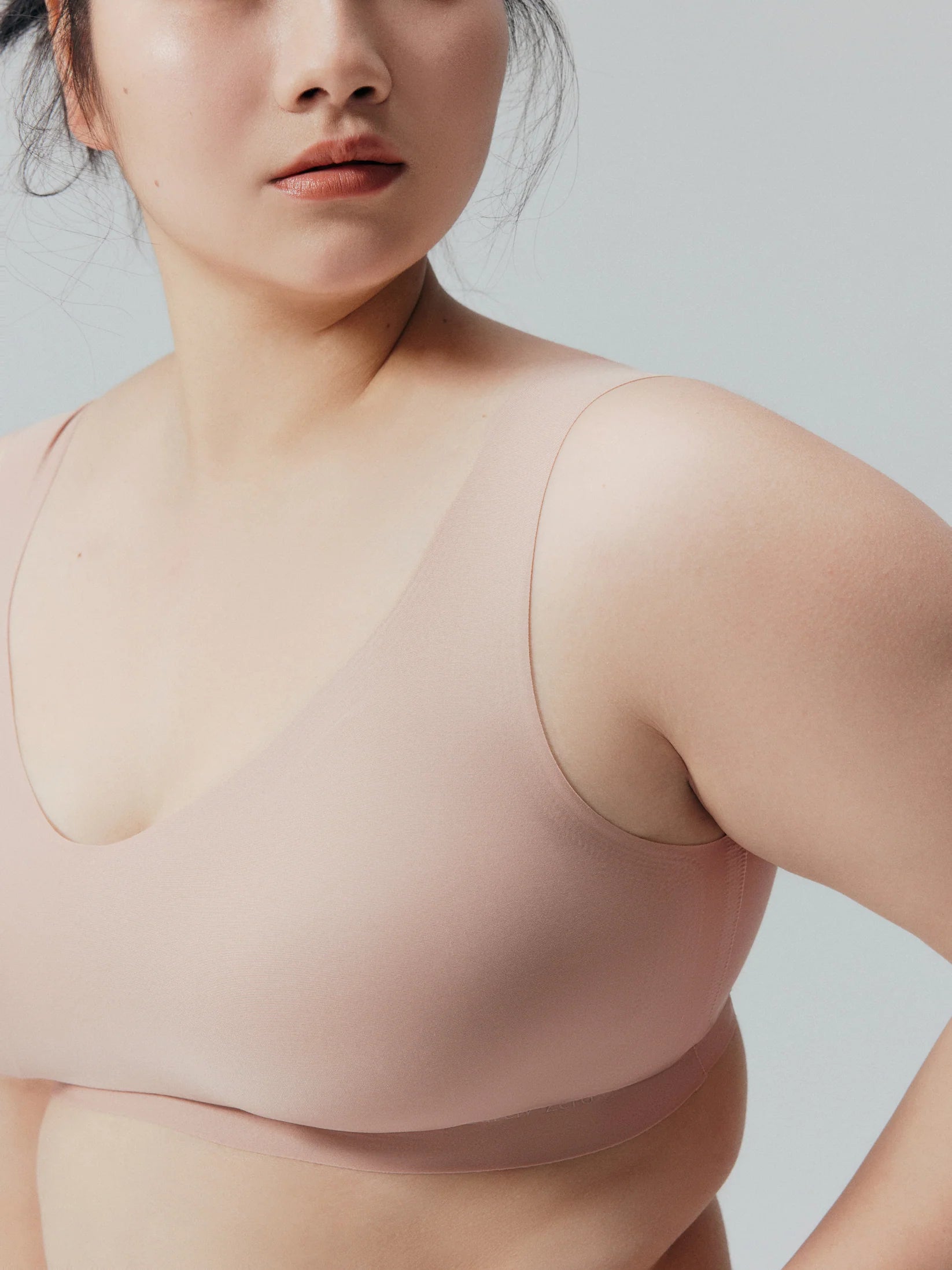 Woman wearing a beige compression garment against a light gray background