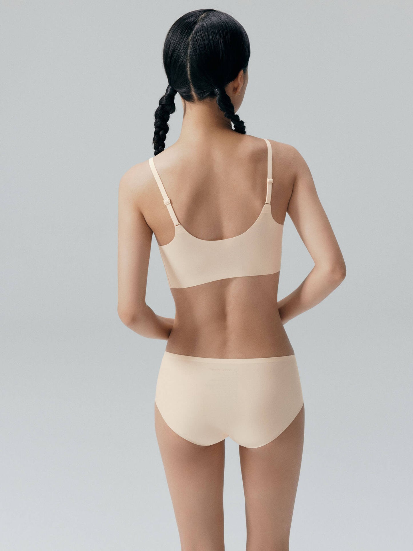 Back view of model wearing cream colored bra and brief set.