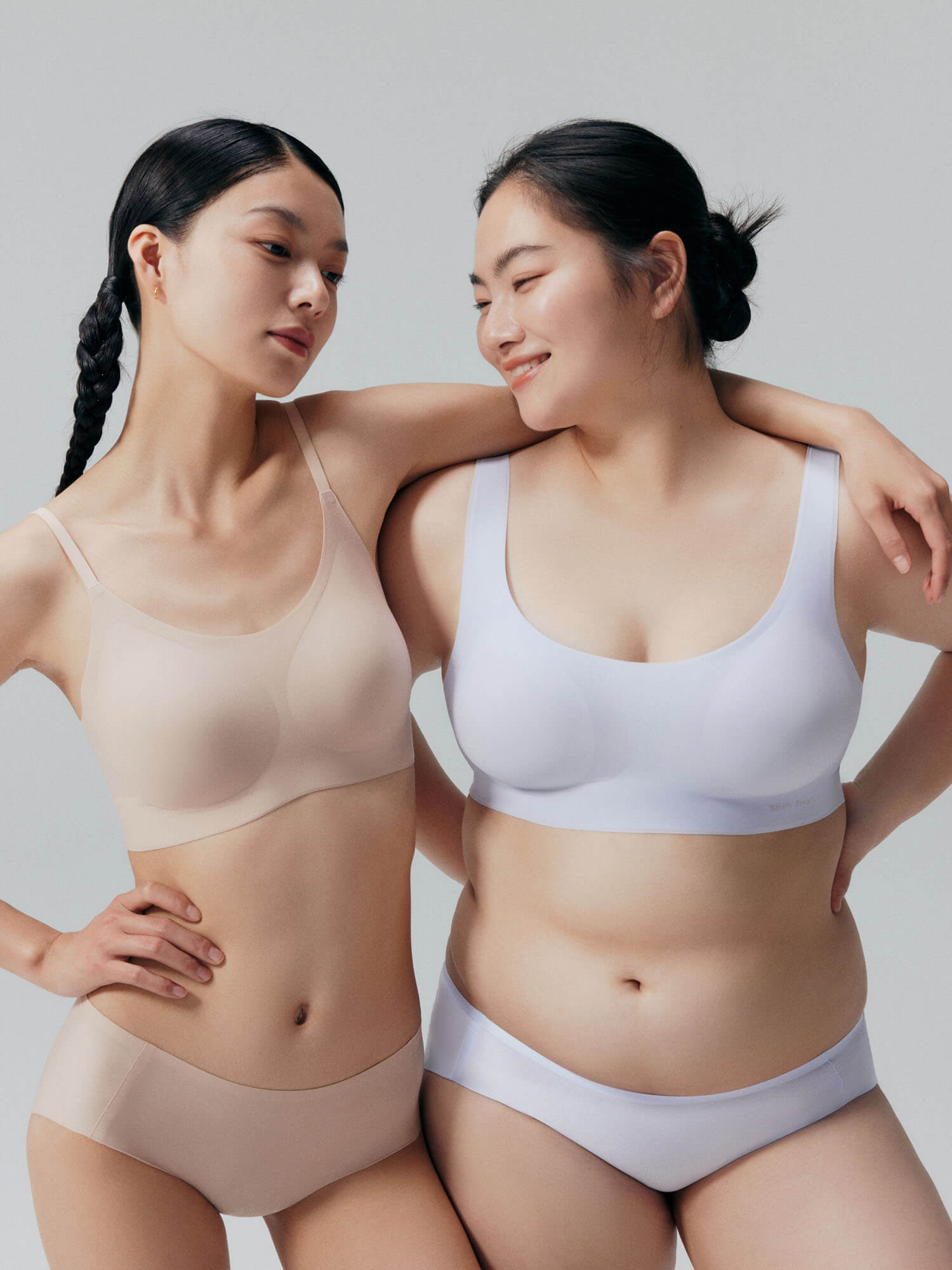 Two models wearing Barely Zero bra and brief set.