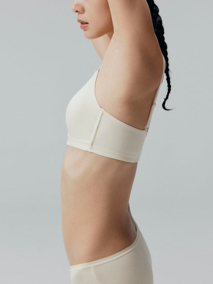 Side view of model wearing a beige bra and matching briefs.
