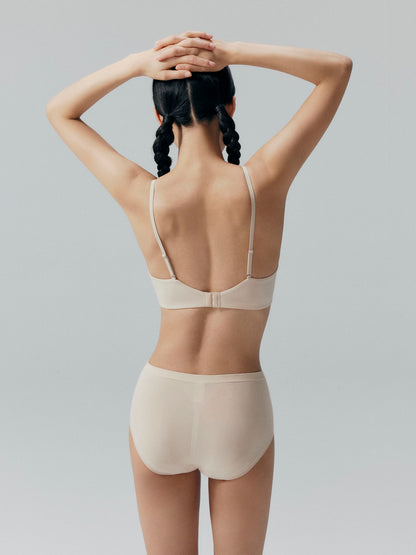 Back view of model wearing a beige bra and matching briefs.