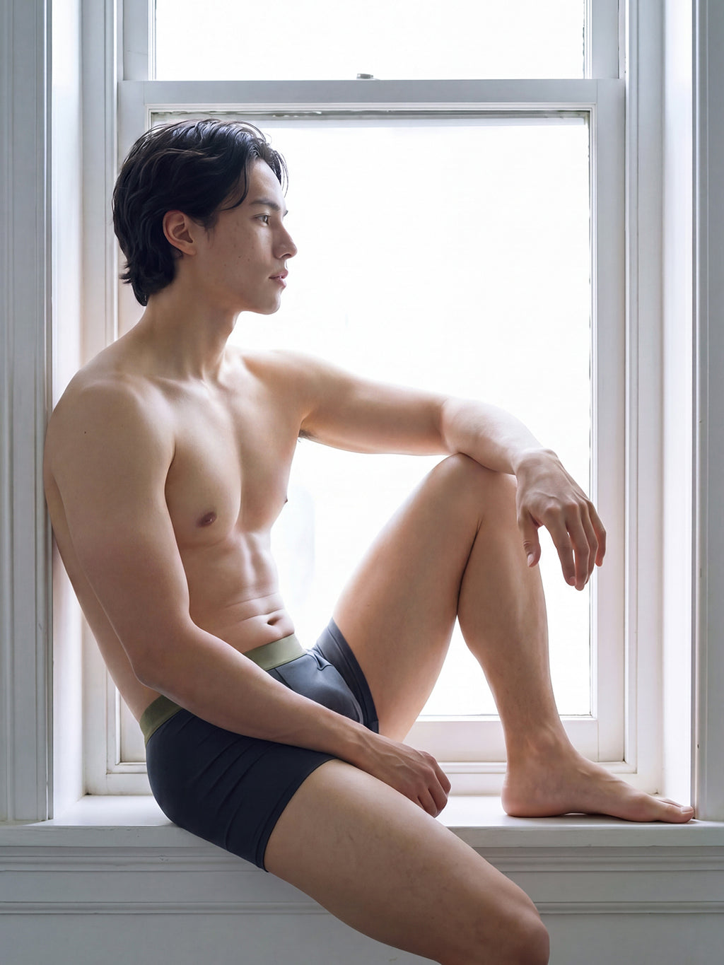 Male model in briefs seated on windowsill. Steel Blue color. 