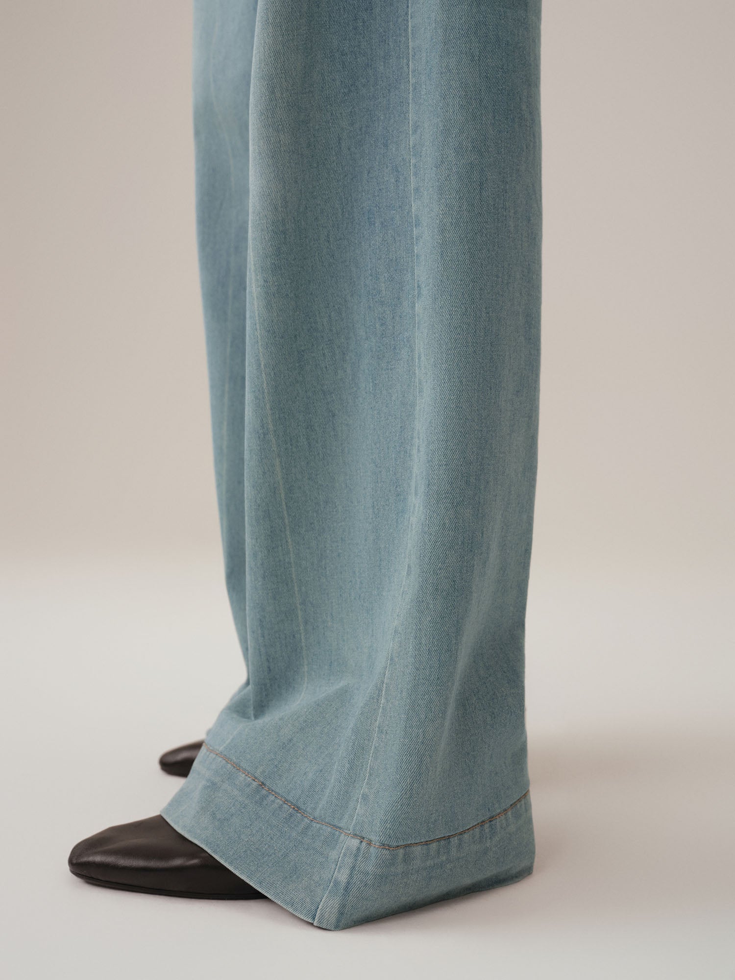 Close up of bottom hem on light blue jeans