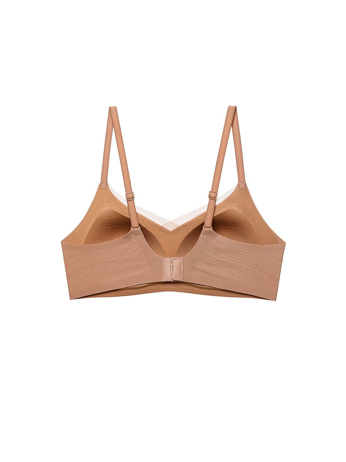 A seamless wireless bra in a warm nude beige color, shown from the back on a solid white background. Sandstone