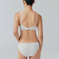 Back view of model wearing light gray bra and brief set.