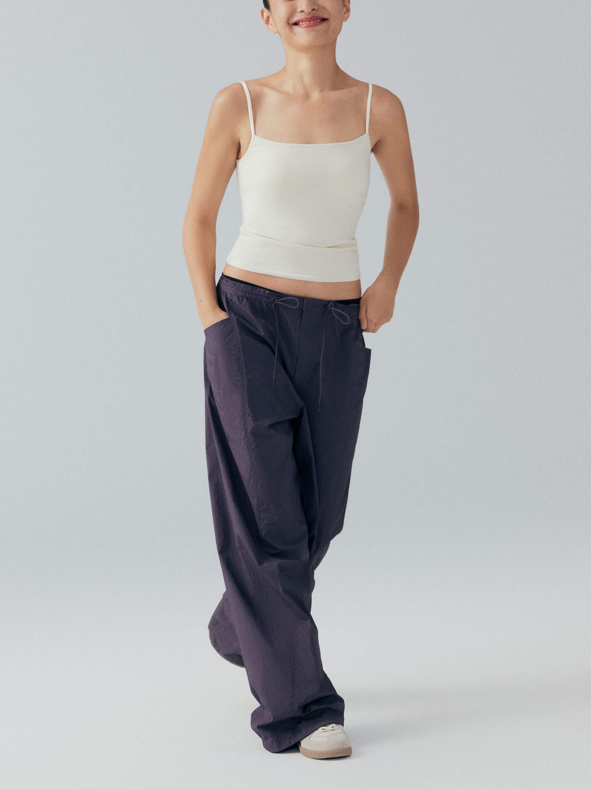 Model wearing white camisole top and cargo pants