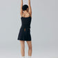 Model wearing black camisole top and black skirt with arms raised