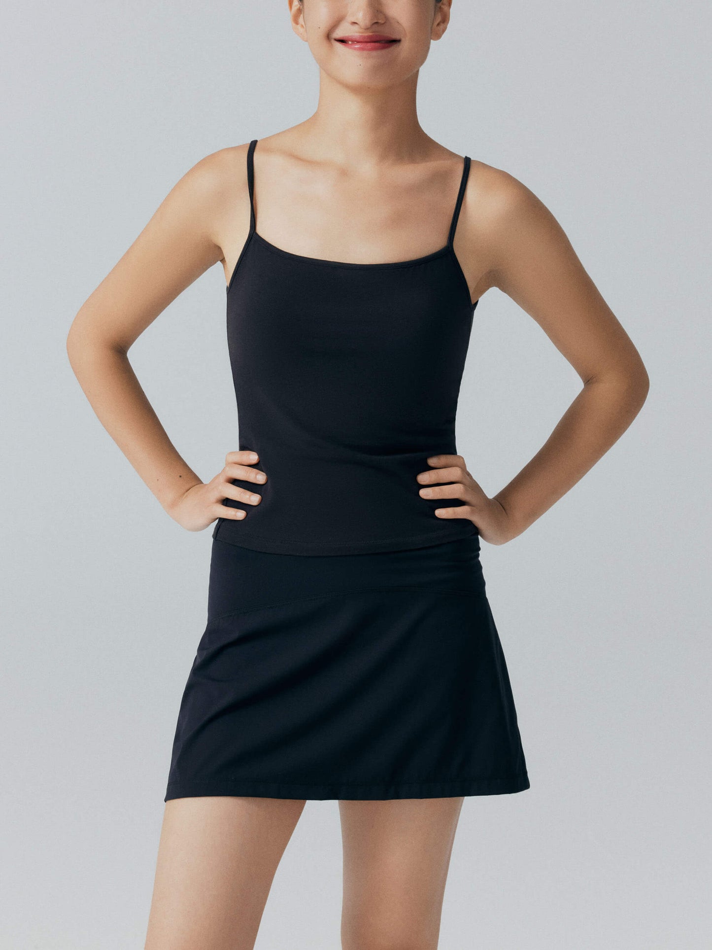 Model wearing black camisole top and black skirt.