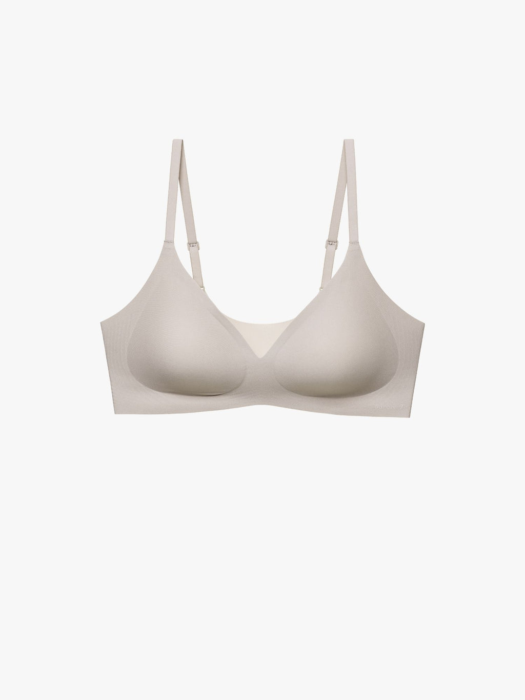 A seamless wireless bra in a light beige or cream color, shown from the front against a solid off-white background. Chateau Gray