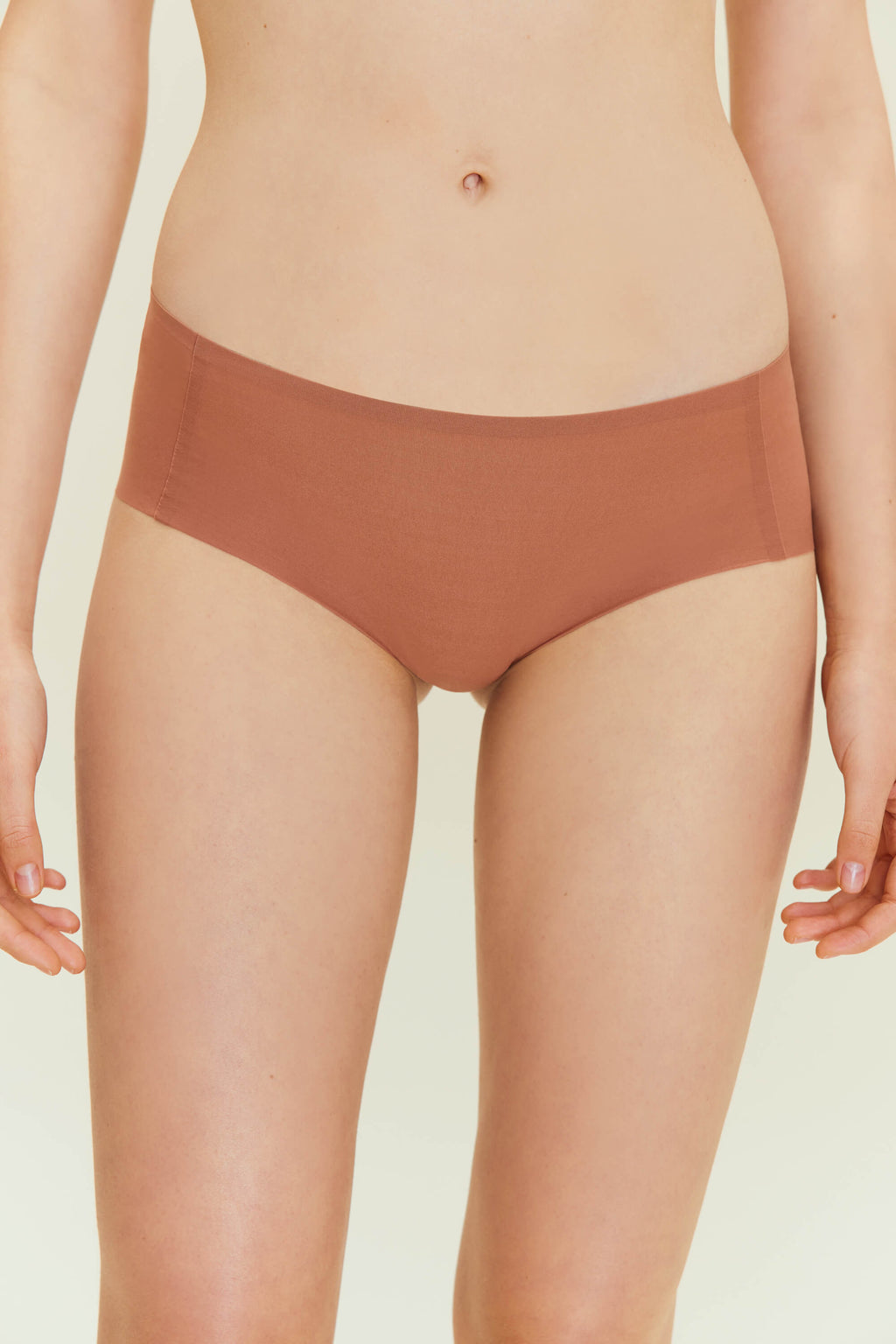 Front view of woman wearing rust-colored underwear. Cinnamon Taste color.