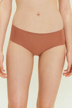 Front view of woman wearing rust-colored underwear. Cinnamon Taste color.