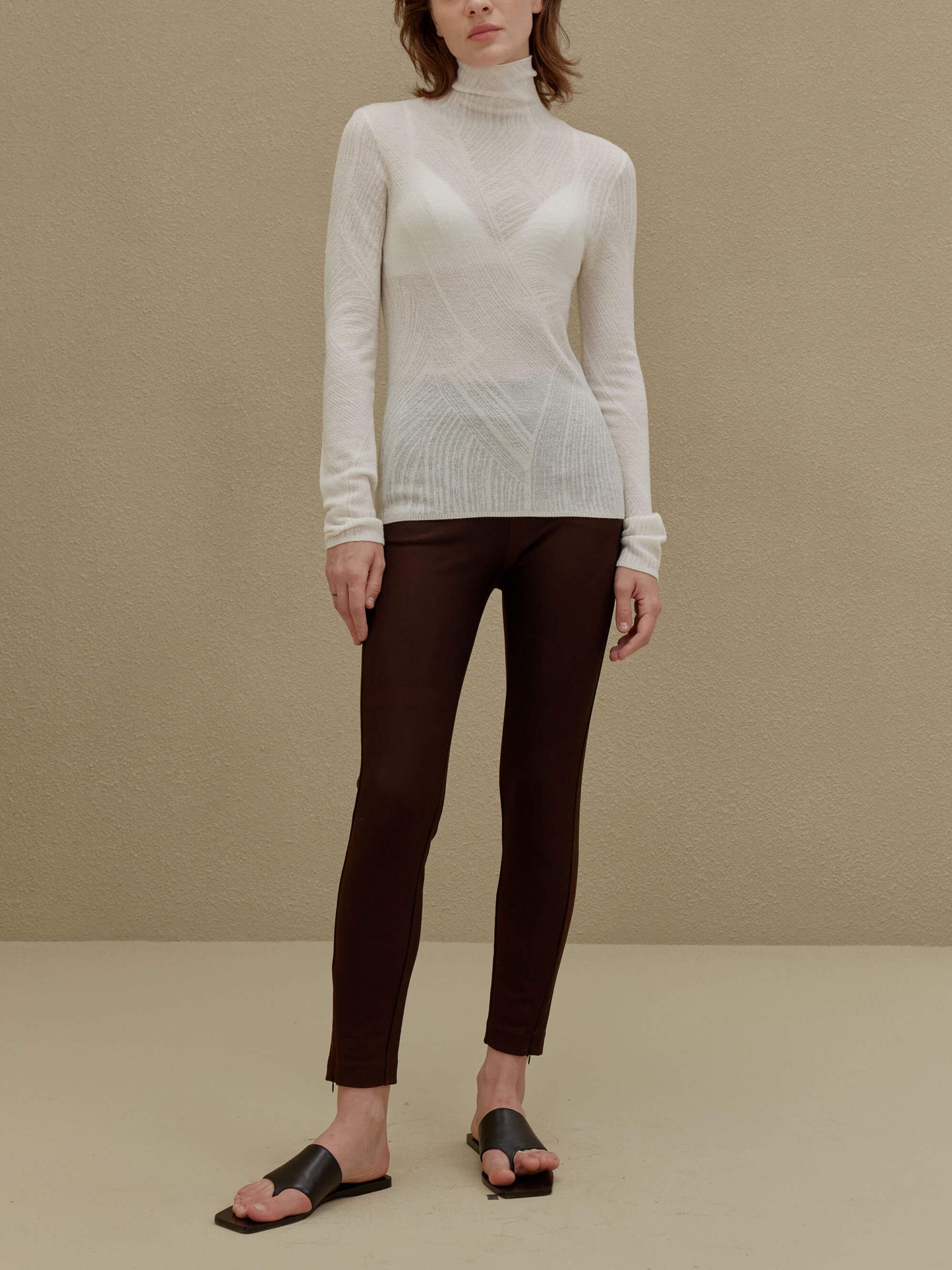 woman in white turtleneck sweater and brown pants