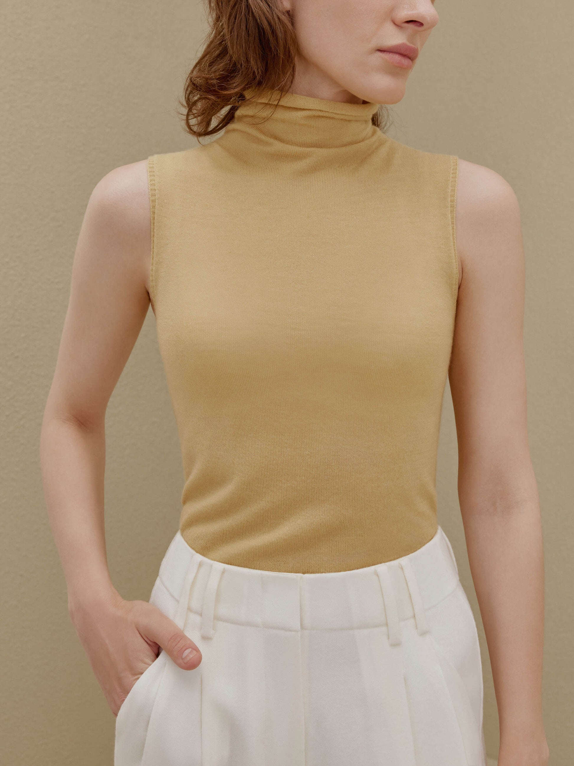 Woman in yellow knit turtle neck sleeveless top