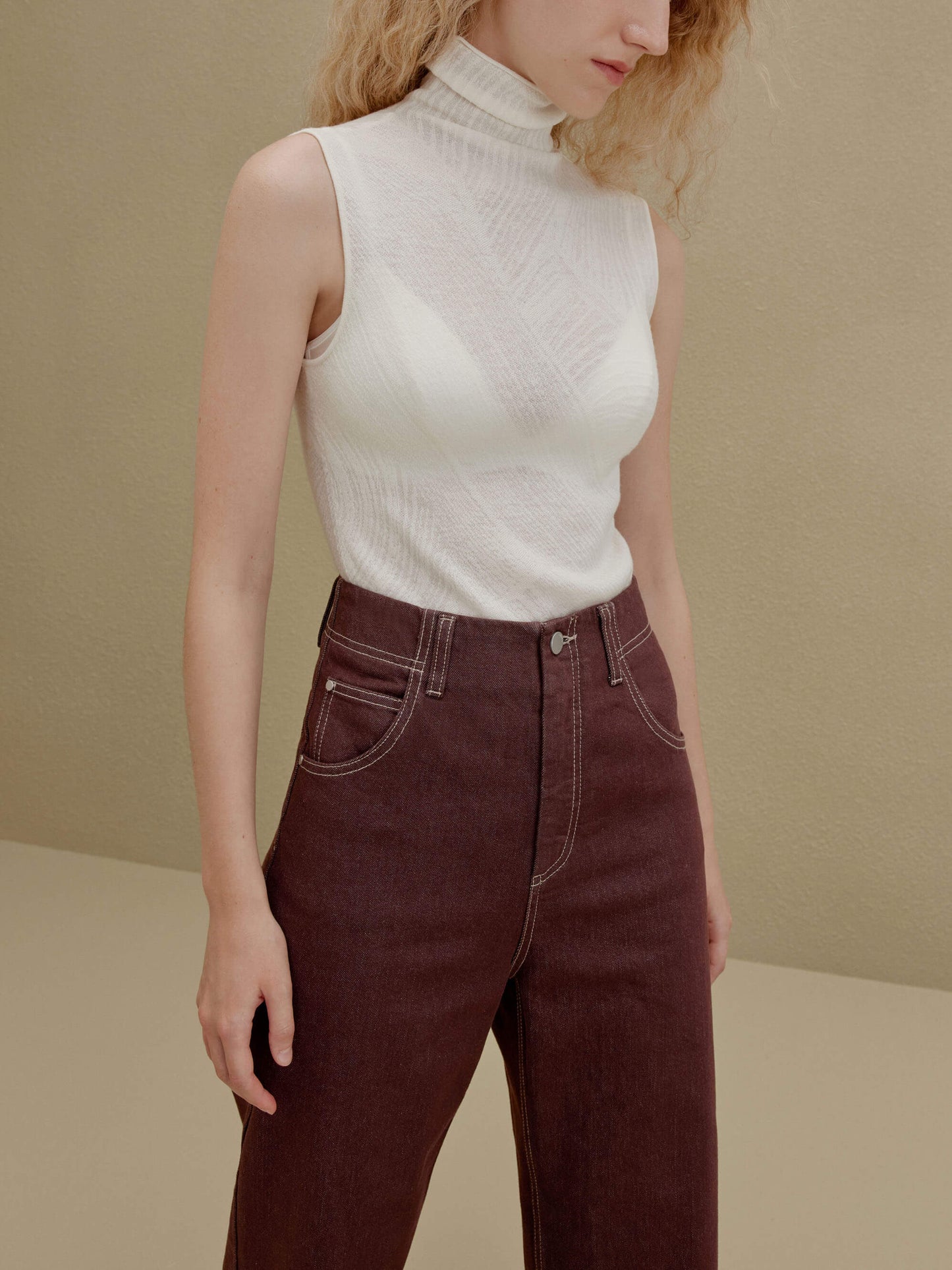 woman in white sleeveless top and brown pants