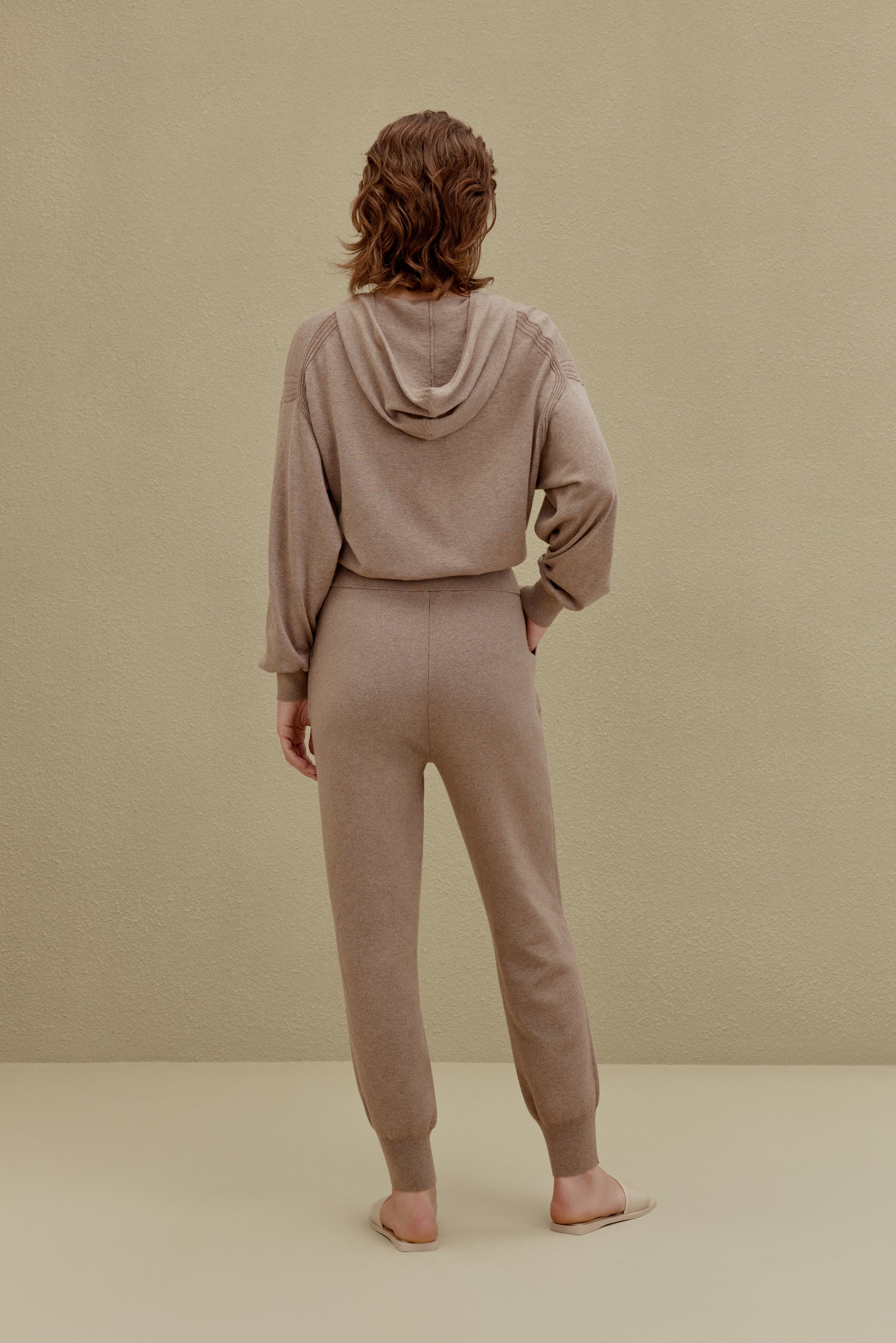 A woman wearing a Camel hoodie and pants, back