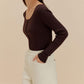 woman in brown cardigan and white pants