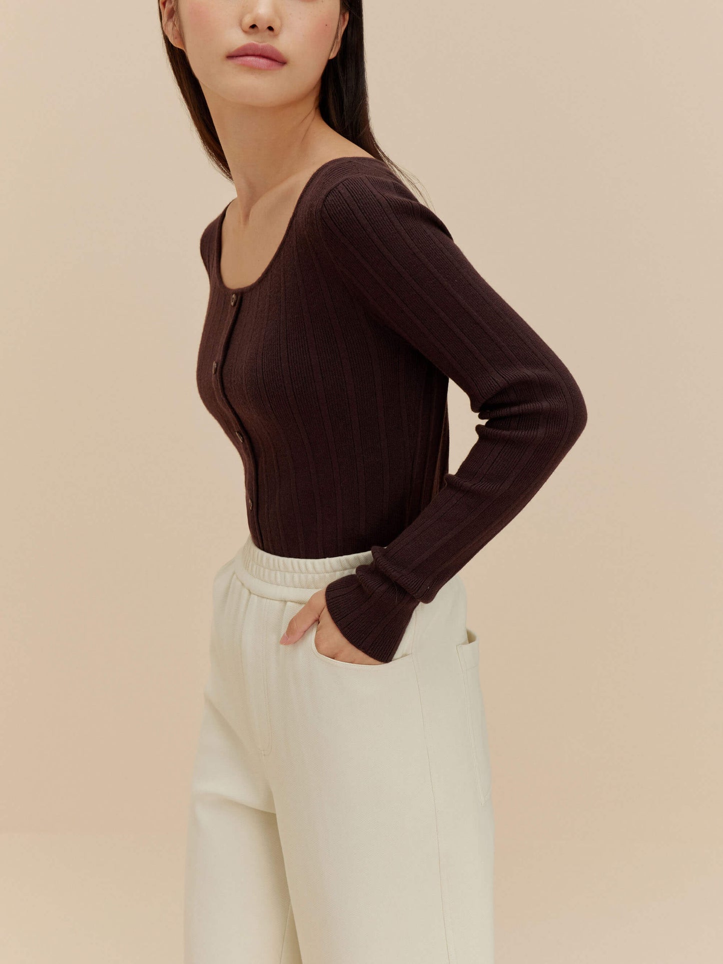 woman in brown cardigan and white pants