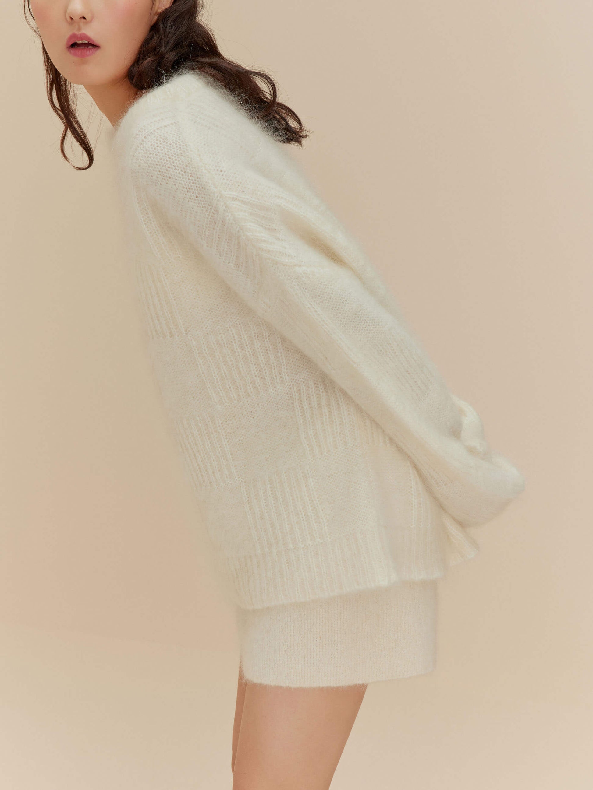 Side view of woman in white sweater