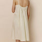 Back of woman wearing off-white spaghetti strap pajama dress