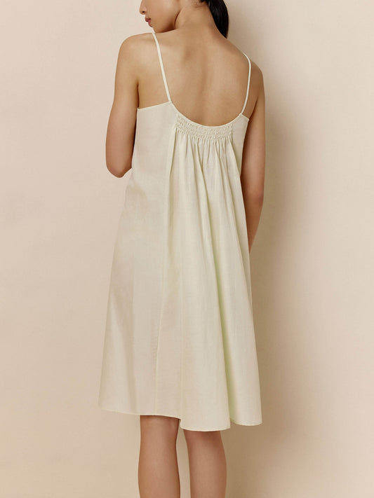 Back of woman wearing off-white spaghetti strap pajama dress