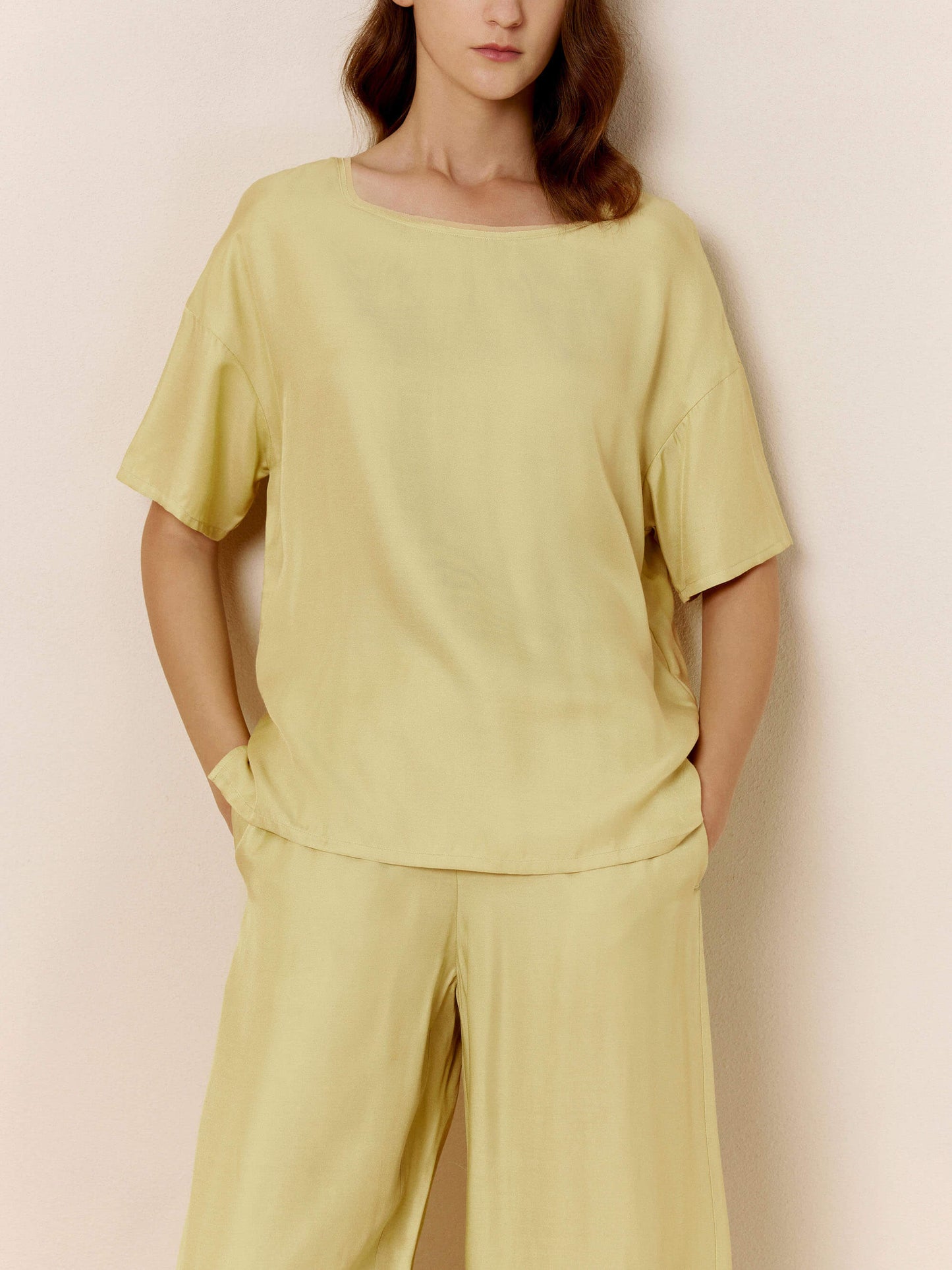 Front view of model wearing light green silk blend pajama top.