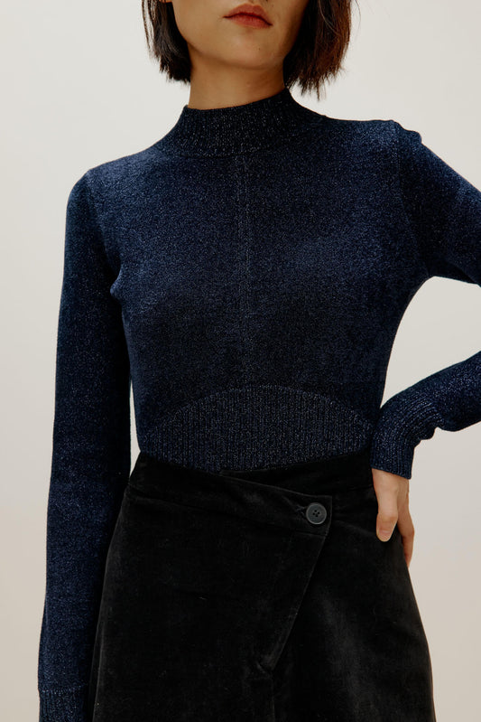 woman wearing blue shimmer mock neck sweater